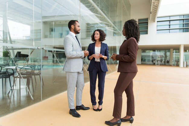 Multiethnic team discussing project near office building