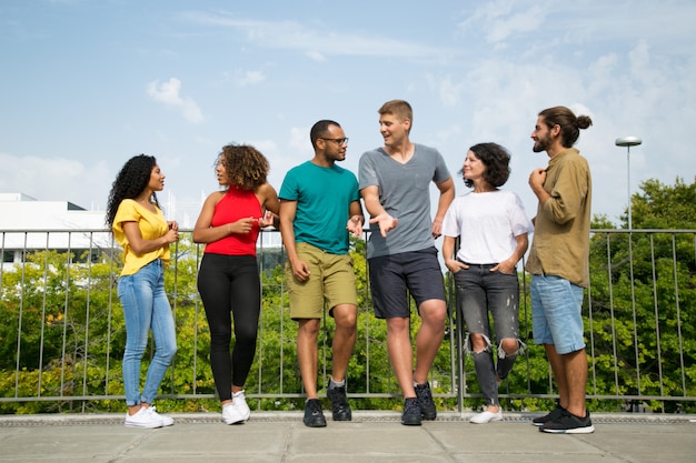 Multiethnic team of friends chatting on bridge