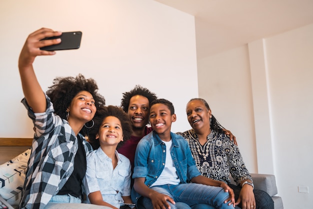 Multigenerational family taking selfie with phone at home.