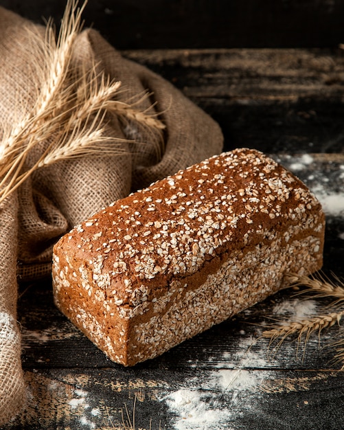 Free photo multigrain bread with wheat and flour on table