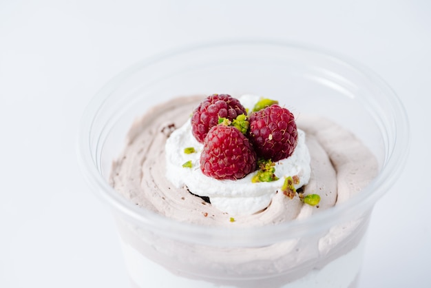 Multiple layer cream dessert topped with raspberries and pistachio