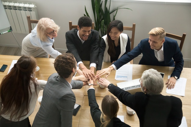 Free photo multiracial business people put hands together at group team meeting