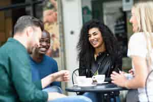 Free photo multiracial group of four friends having a coffee together