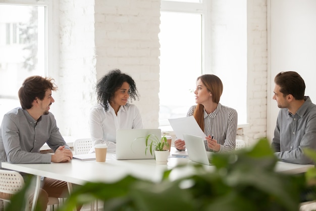 Multiracial male and female colleagues having discussion at team meeting