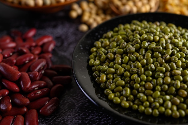 Free photo mung bean and red bean on a black cement floor.