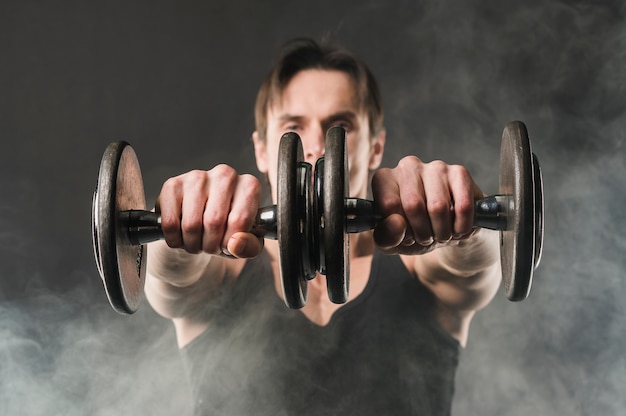 Free photo muscly man holding up weights