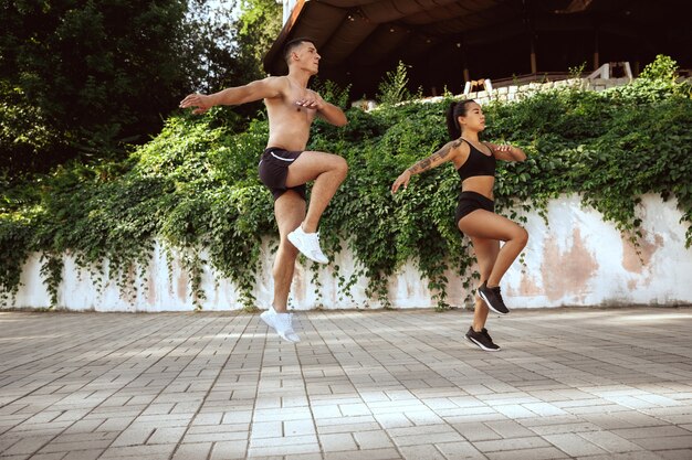 A muscular athletes doing workout at the park. Gymnastics, training, fitness workout flexibility.