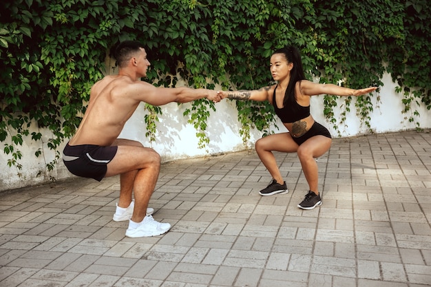 A muscular athletes doing workout at the park