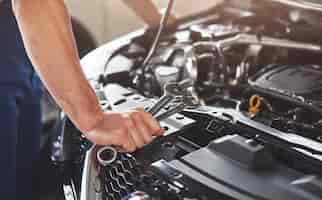 Free photo muscular car service worker repairing vehicle.