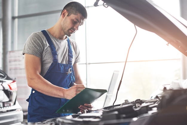 Free Photo muscular car service worker repairing vehicle.