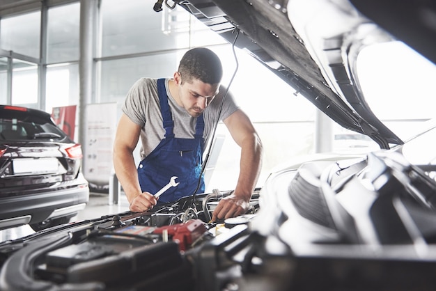 muscular car service worker repairing vehicle.