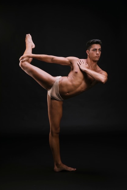 Free photo muscular dancer stretching leg and shoulder