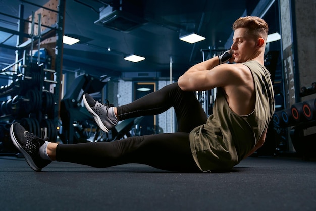 Muscular man doing crunches on floor