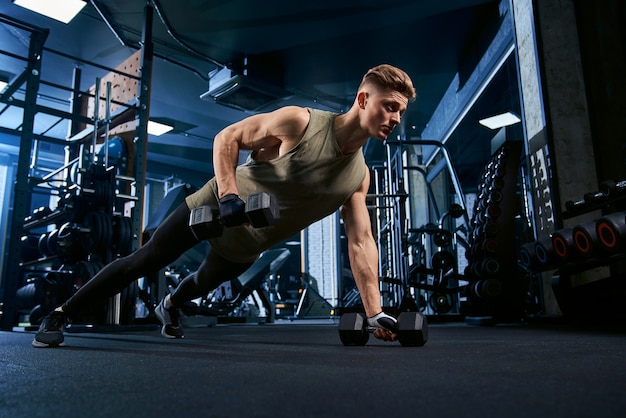 Muscular man doing push ups on one hand.