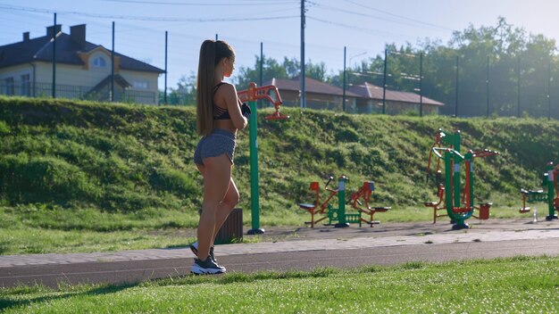 Muscular woman walking at stadium in morning