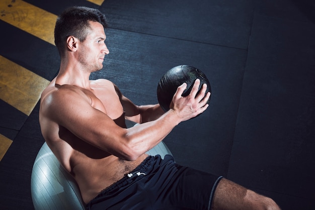 Muscular young man exercising with medicine ball