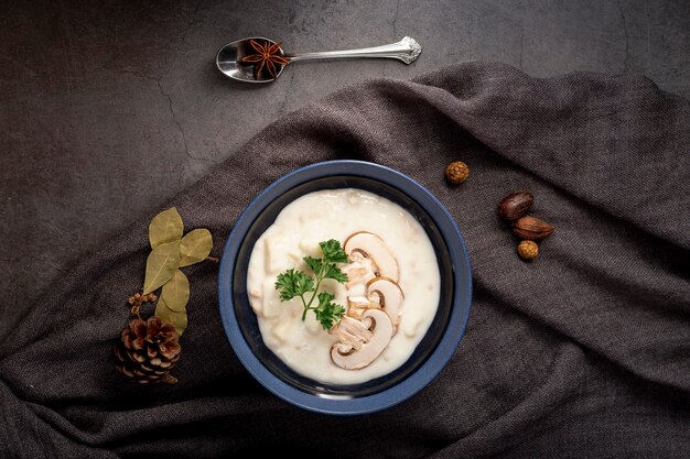 Mushroom soup in a jar on a grey scarf and a spoon