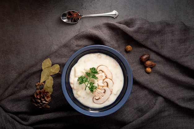 Mushroom soup in a jar on a grey scarf and a spoon