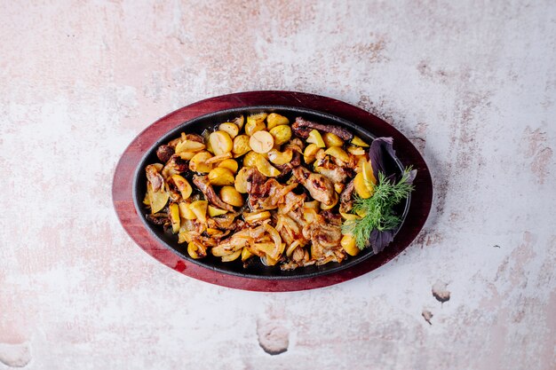 Mushroom stew with beans and chestnuts with a bunch of dill in black pan.