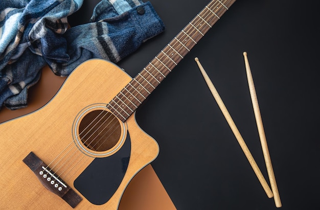 Free photo music background with guitar and drumsticks top view