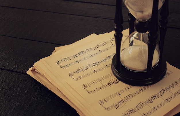 Free photo music notes on papers and hourglass