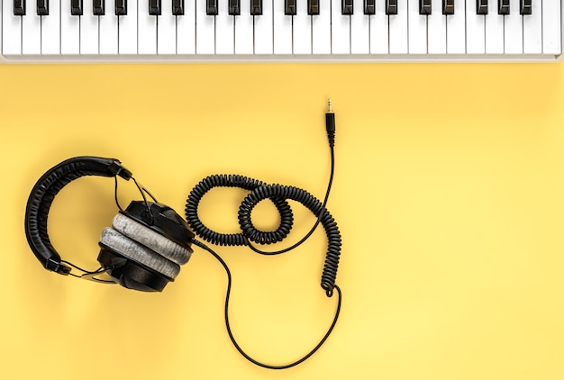 Free photo musical flat lay background with headphones and musical keys.