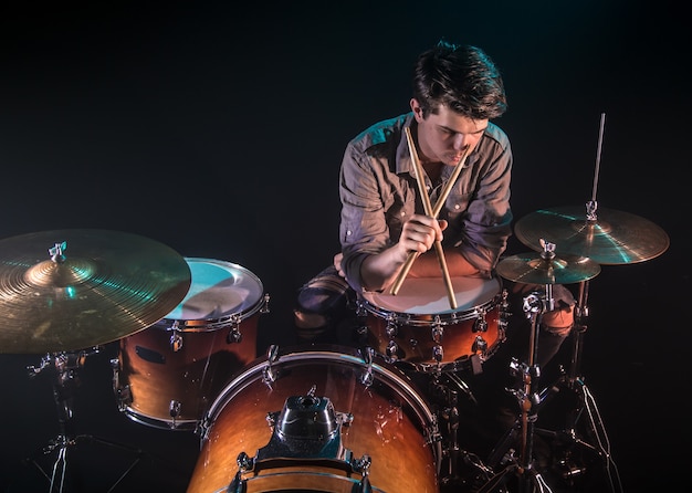 musician playing drums, black background and beautiful soft light, emotional play, music concept