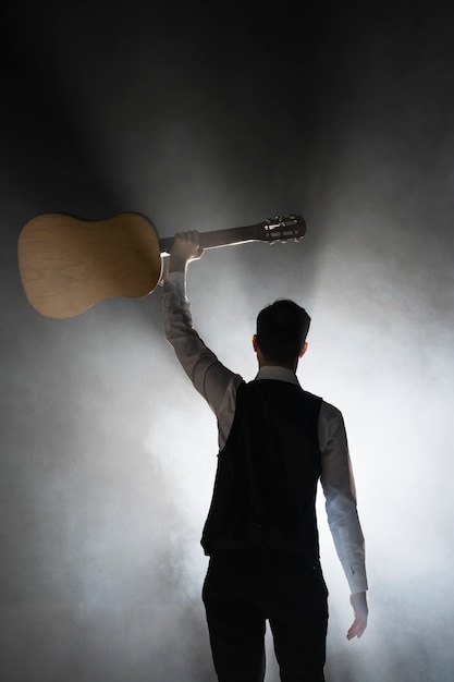 Free Photo musician on stage holding his classical guitar