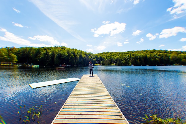 Free Photo musician standing in front of lake under sunny sky