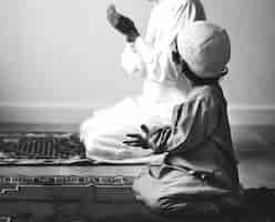 Free photo muslim boy learning how to make dua to allah