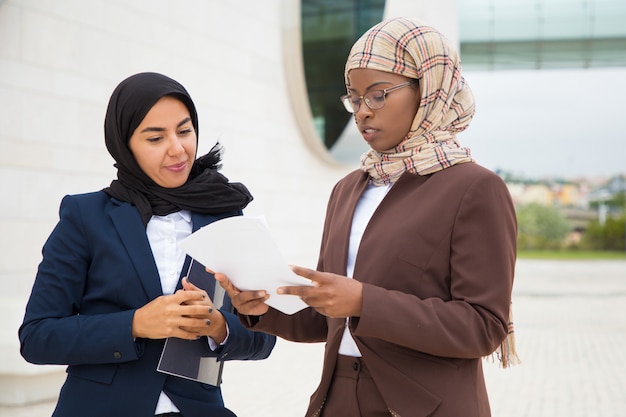 Muslim business women discussing contract text