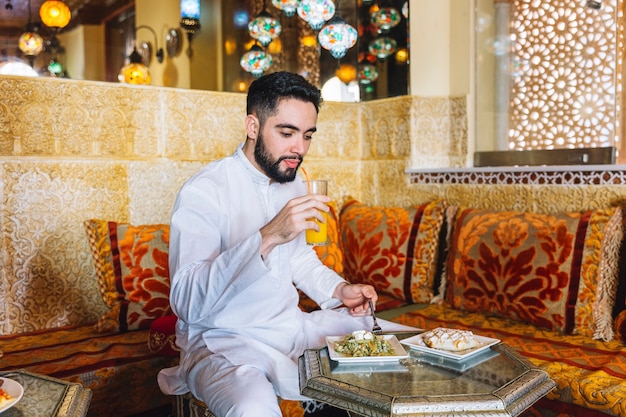 Free Photo muslim man eating in restaurant