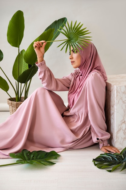 Muslim woman holding leaf side view