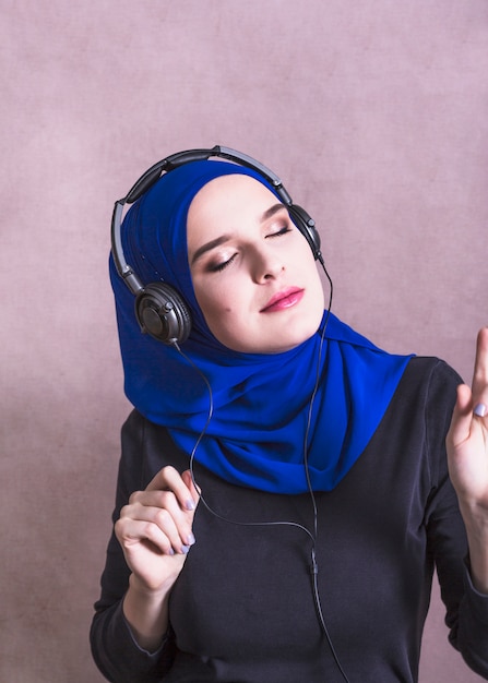 Free Photo muslim woman listening to music on headphones