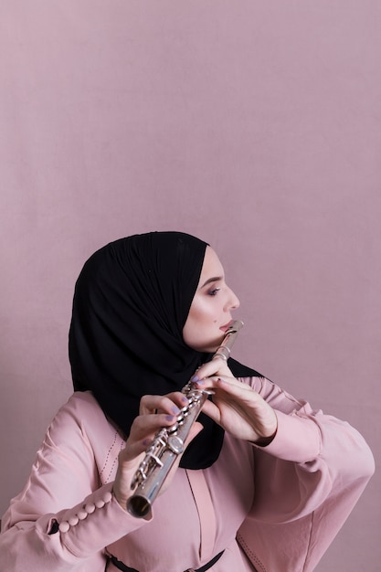 Free Photo muslim woman playing on the flute