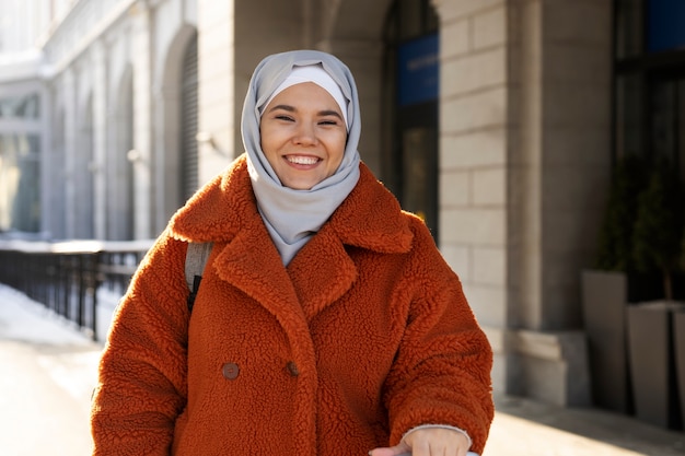 Free photo muslim woman with hijab leaving the hotel and smiling while being on vacation