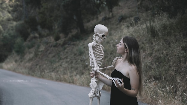 Free photo mysterious lady holding skeleton