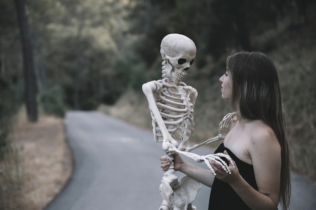 Free Photo mysterious woman holding skeleton