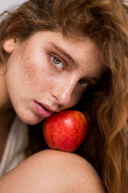 Free photo mysterious woman posing with red apple close-up