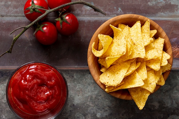 Free Photo nachos in bowl and tomato sauce on table