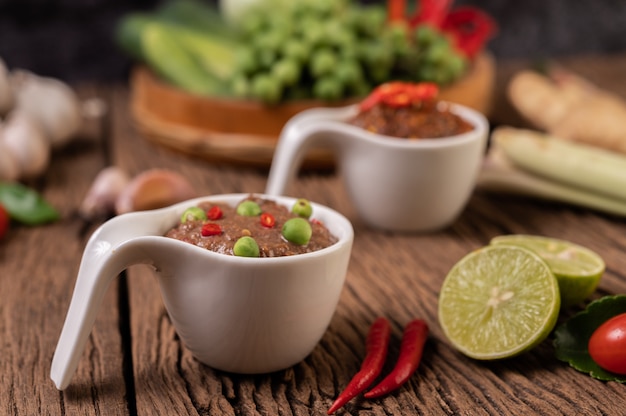 Free Photo nam phrik kapi  with chili and lemon on wooden floor.