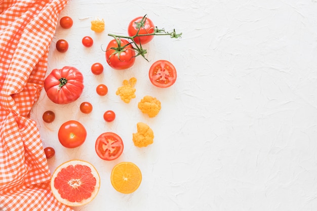 Napkin with vegetables and fruits on white textured backdrop