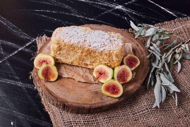 Napoelon cake with figs and leaves on wool tablecloth. 