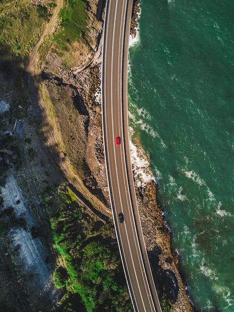 Free photo a narrow curvy road with cars alongside green mountains