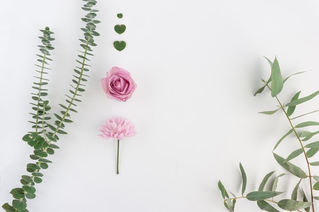 Natural composition with two pink flowers and floral hearts