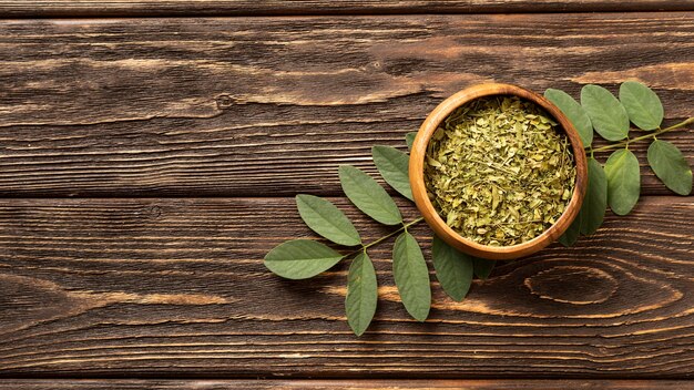 Natural crushed green leaves in a bowl copy space