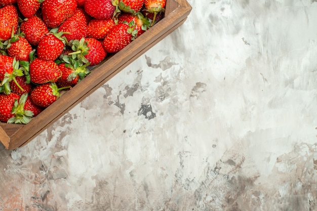 Free photo natural and fresh red strawberries in small brown wooden box