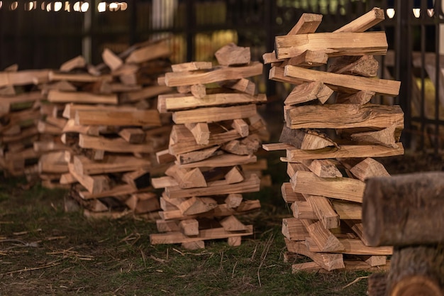 Free photo neatly stacked firewood in the backyard in the evening