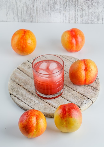 Free photo nectarines with juice, cutting board, high angle view on white and grungy wall