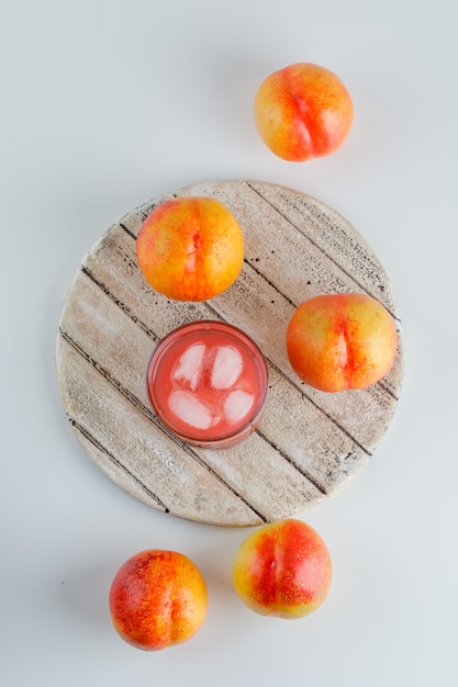 Free photo nectarines with juice top view on white and cutting board table